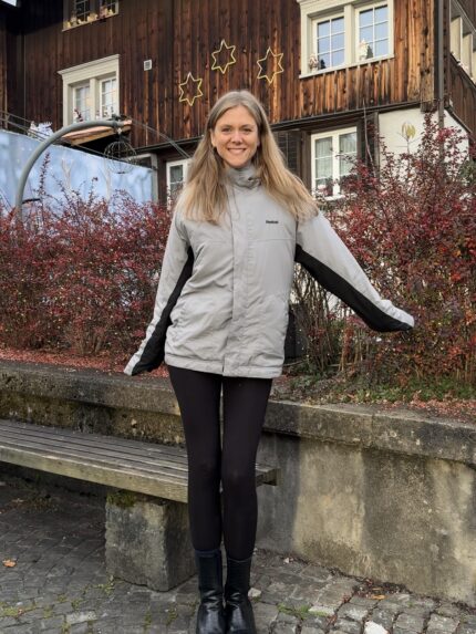 Blondine trägt Vintage Reebok Winterjacke in grau
